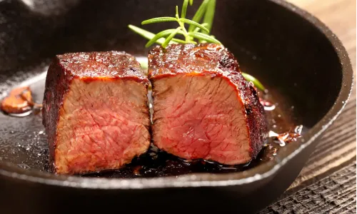 Steak cut in half in cast iron pan