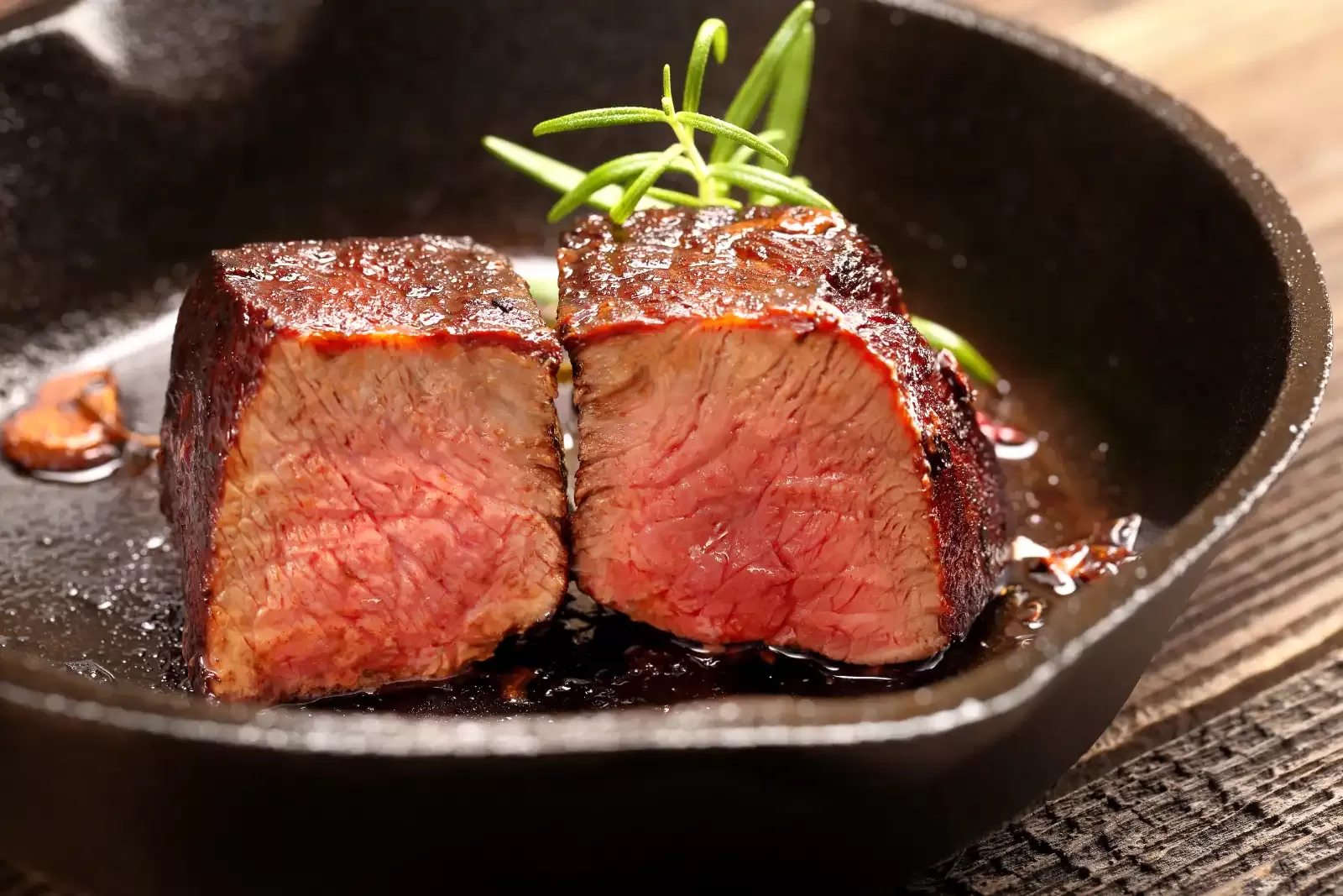 Steak cut in half in cast iron pan